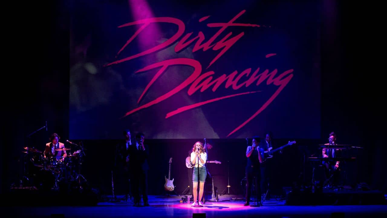 Živá hudobná show Dirty Dancing in Concert s orchestrom a spevákmi na pódiu pod nápisom Dirty Dancing.