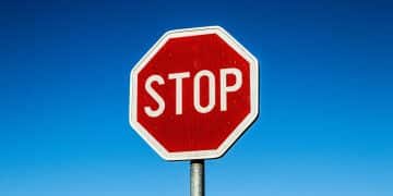 Cestná značka STOP na modrej oblohe symbolizujúca zastavenie alebo uzávierku ciest.