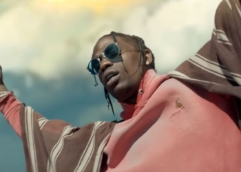 Travis Scott počas vystúpenia s rozpaženými rukami a slnečnými okuliarmi