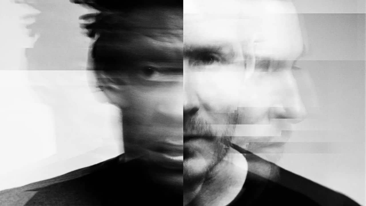 Čiernobiely umelecký portrét dvoch členov skupiny Massive Attack s efektom rozmazania a prekrývania tvárí, zachytávajúci ich mystickú a melancholickú atmosféru.
