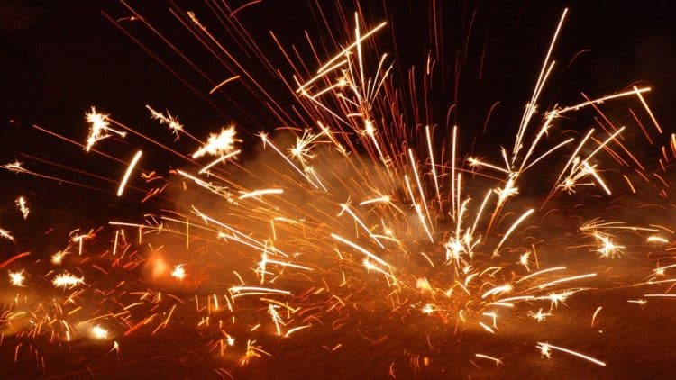 Záblesky zábavnej pyrotechniky počas nočných osláv.