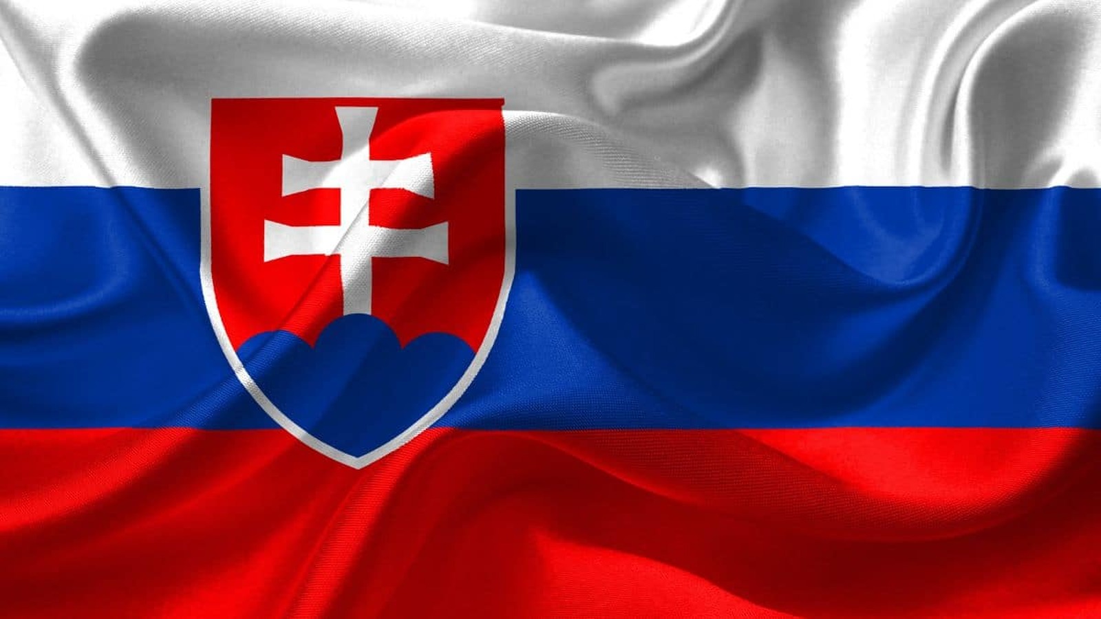 Slovenská vlajka s výrazným štátnym znakom na vlnenom pozadí.