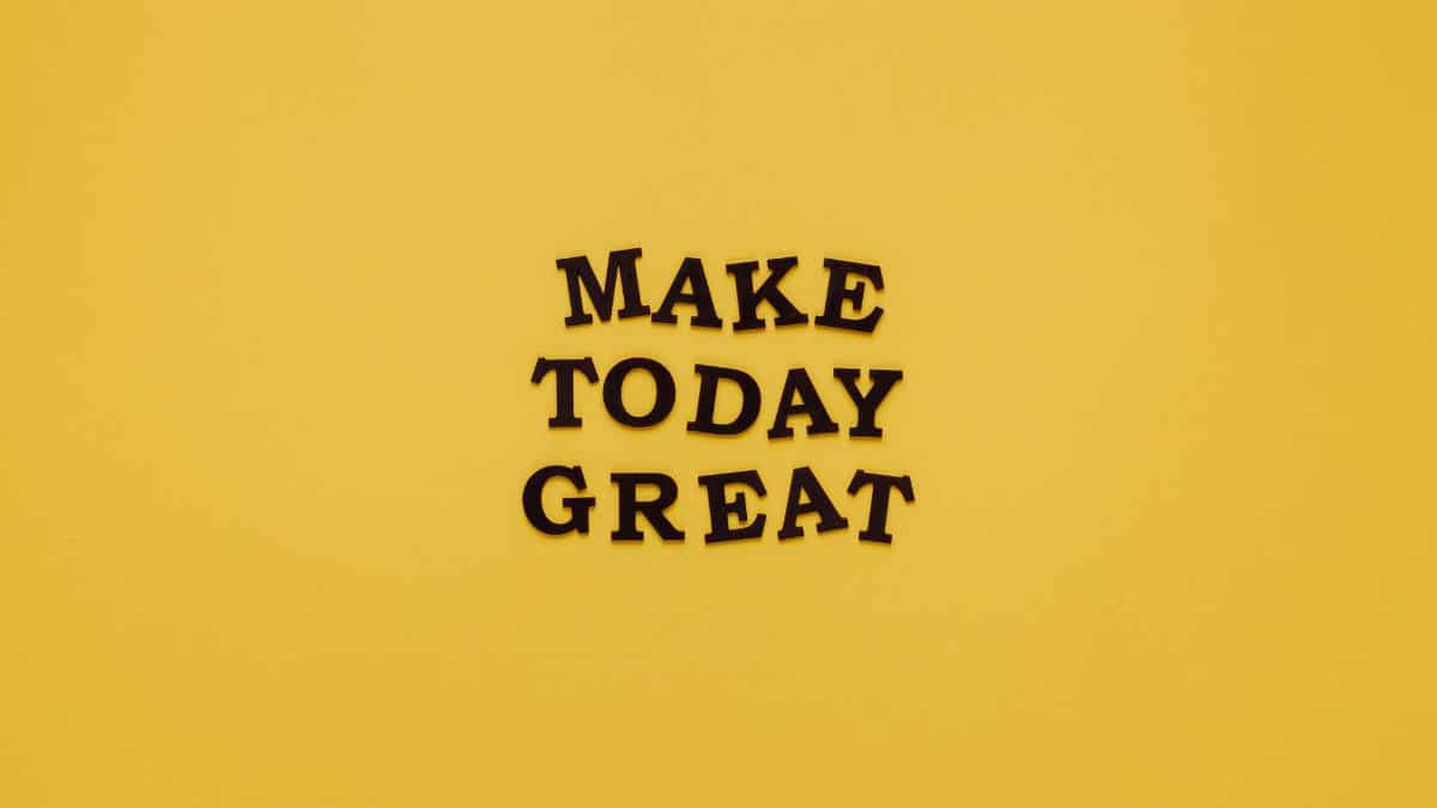 Motivačný citát „Make today great“ napísaný čiernymi písmenami na žltom pozadí.